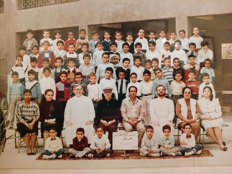 1987 class photograph at Collège de la Sainte Famille: rows of pupils with their teachers seated in front, including Frère Aldo, seated left.